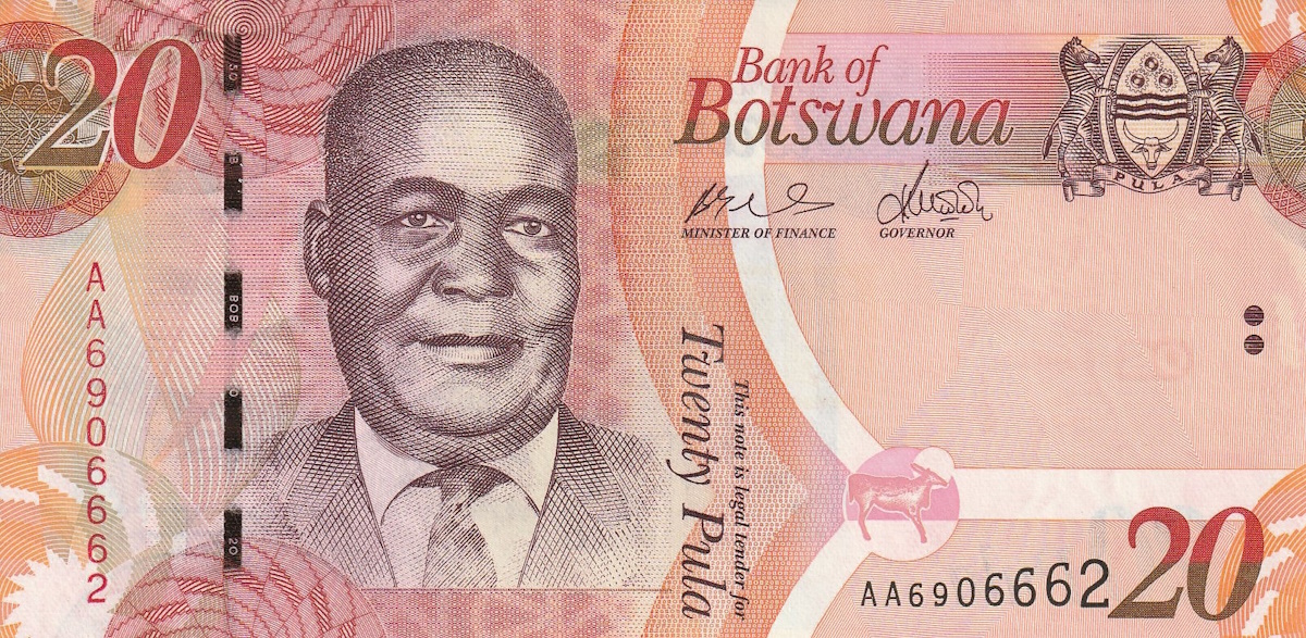 Botswana Pula banknotes and coins displayed on a wooden surface